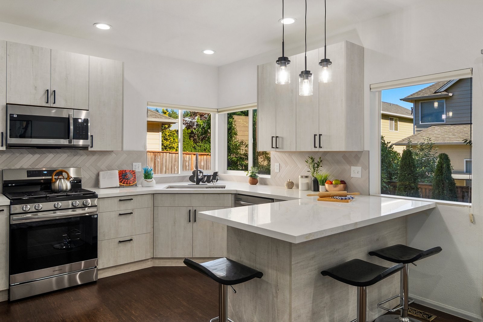 Remodeled kitchen with island, pendant lighting and stainless appliances